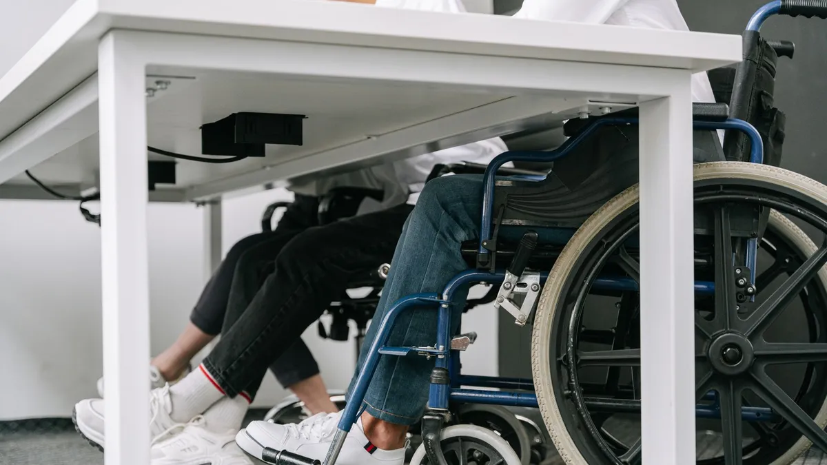 Business setting featuring people working with wheelchair accessibility indoors.