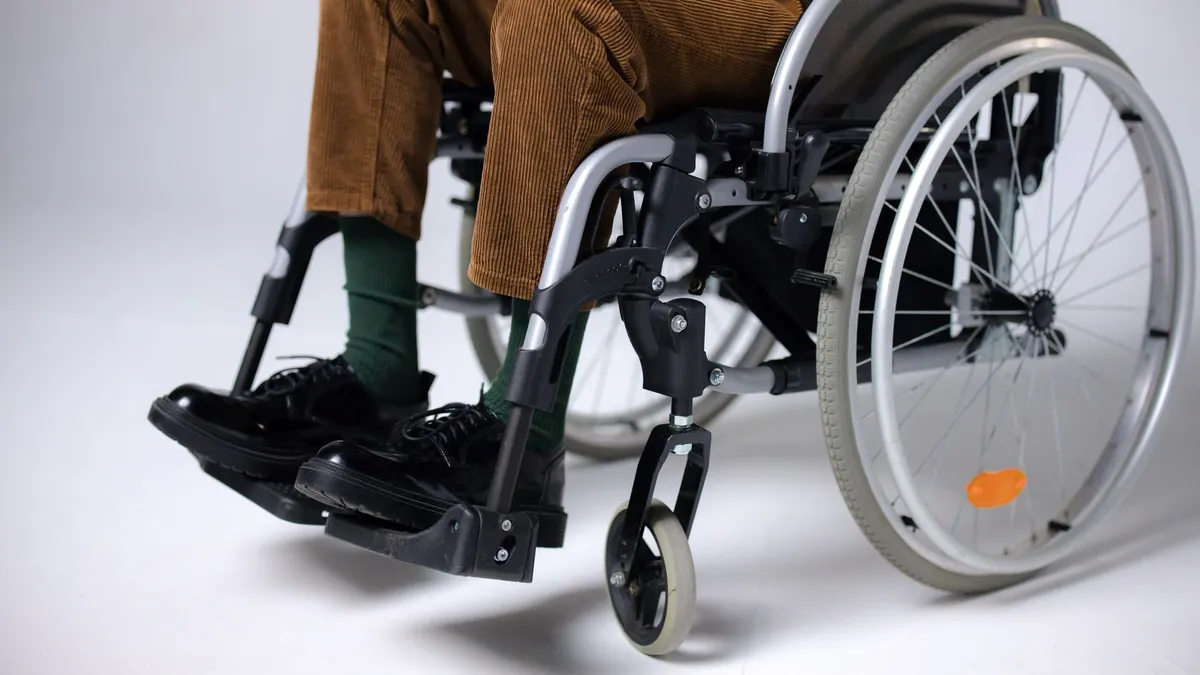 Adult sitting in a wheelchair indoors, focusing on mobility and accessibility.