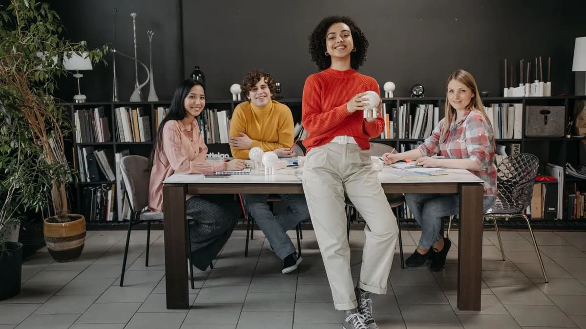Four diverse young adults collaborating in a modern workspace with creative decor.