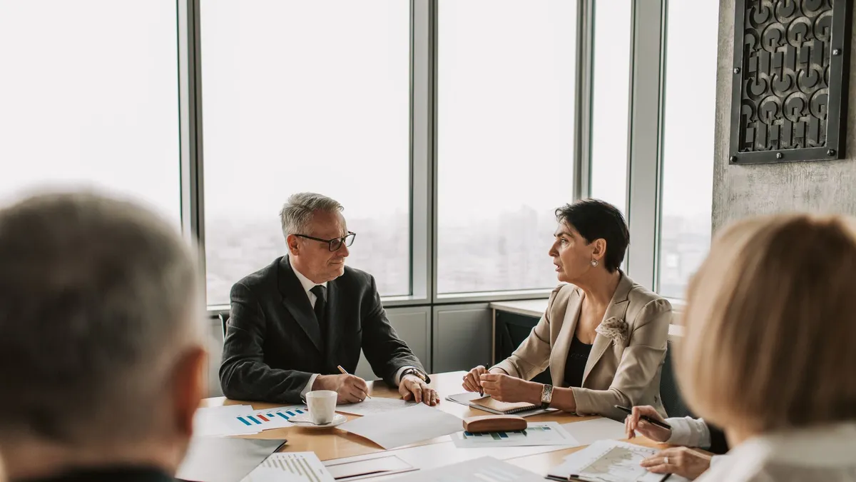 Business professionals engaged in a strategic meeting in a modern office setting with natural light.