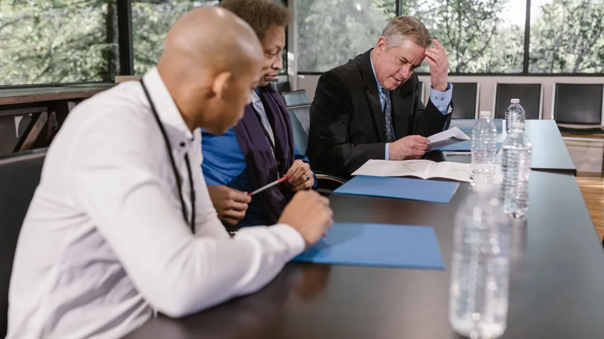 Group of diverse colleagues in a business meeting reviewing documents indoors.