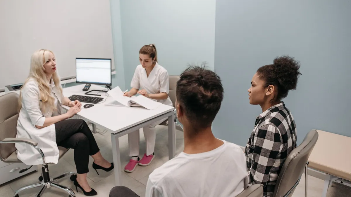 Doctor and patients during a consultation in a modern clinic, teamwork concept.