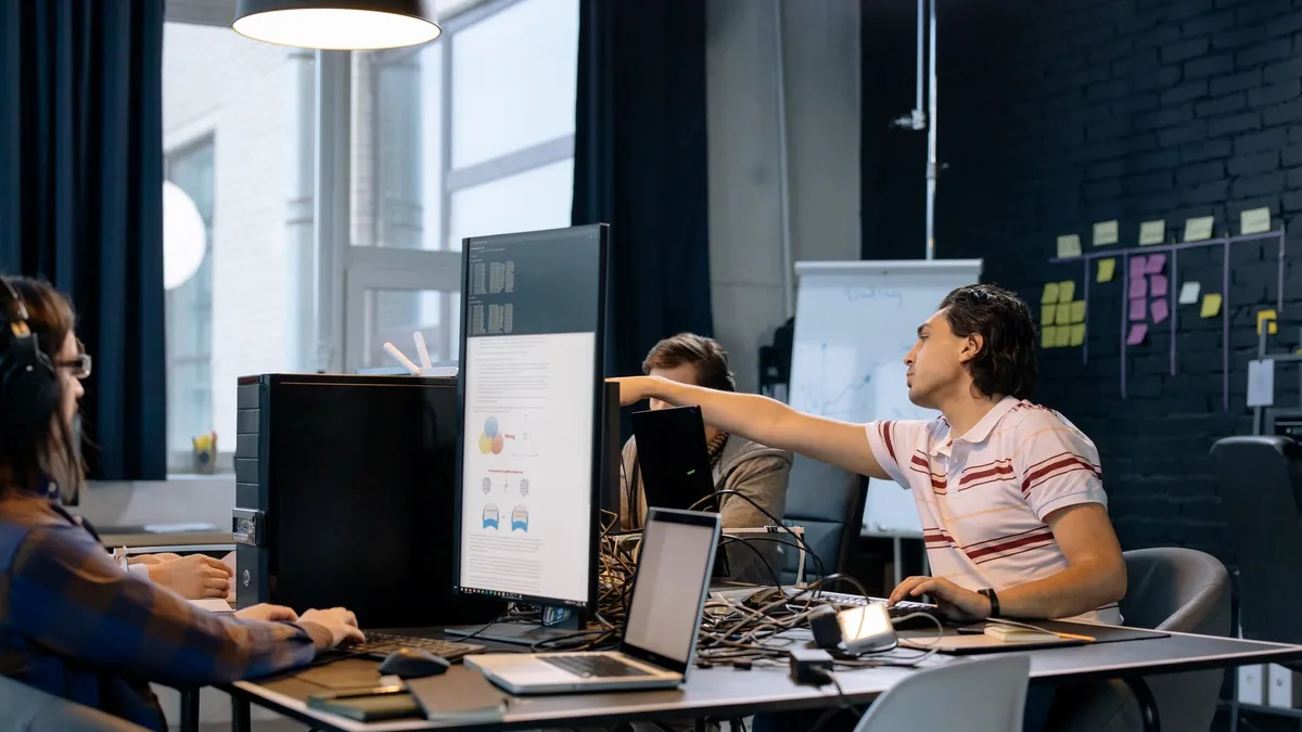 Group of young professionals working on software development in a creative indoor workspace.