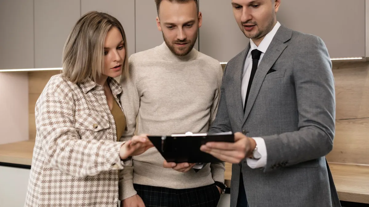 Real estate agent discussing property details with clients indoors.