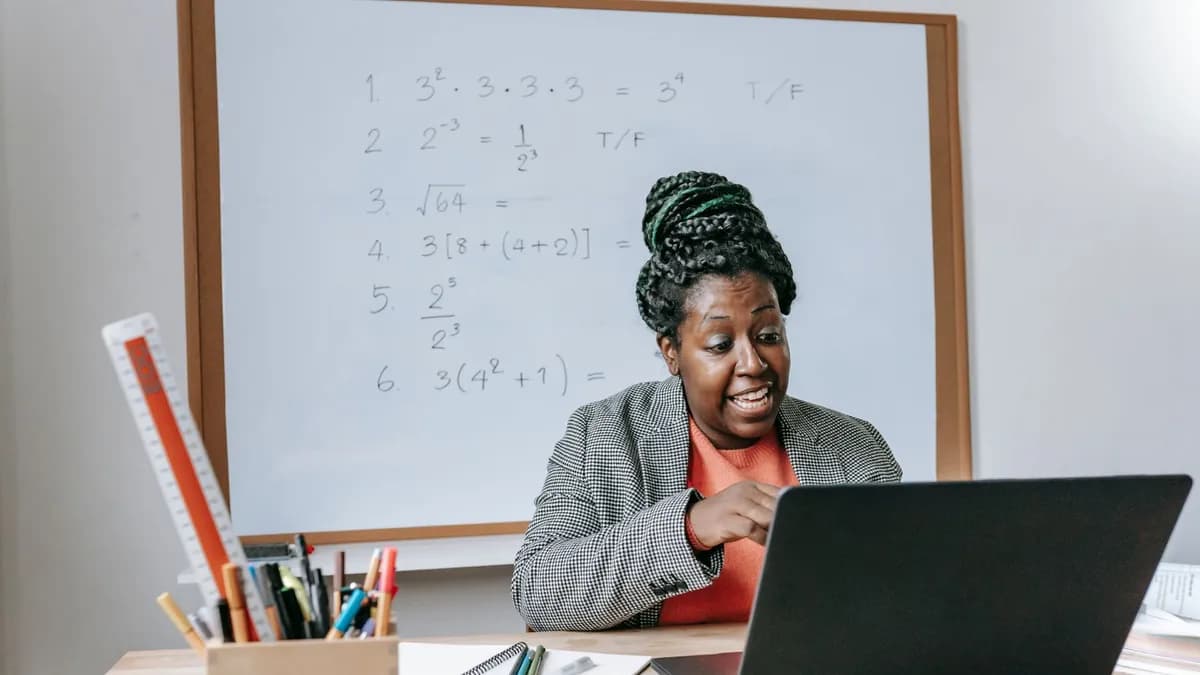Amazed African American female giving lecture in mathematics online on netbook in classroom