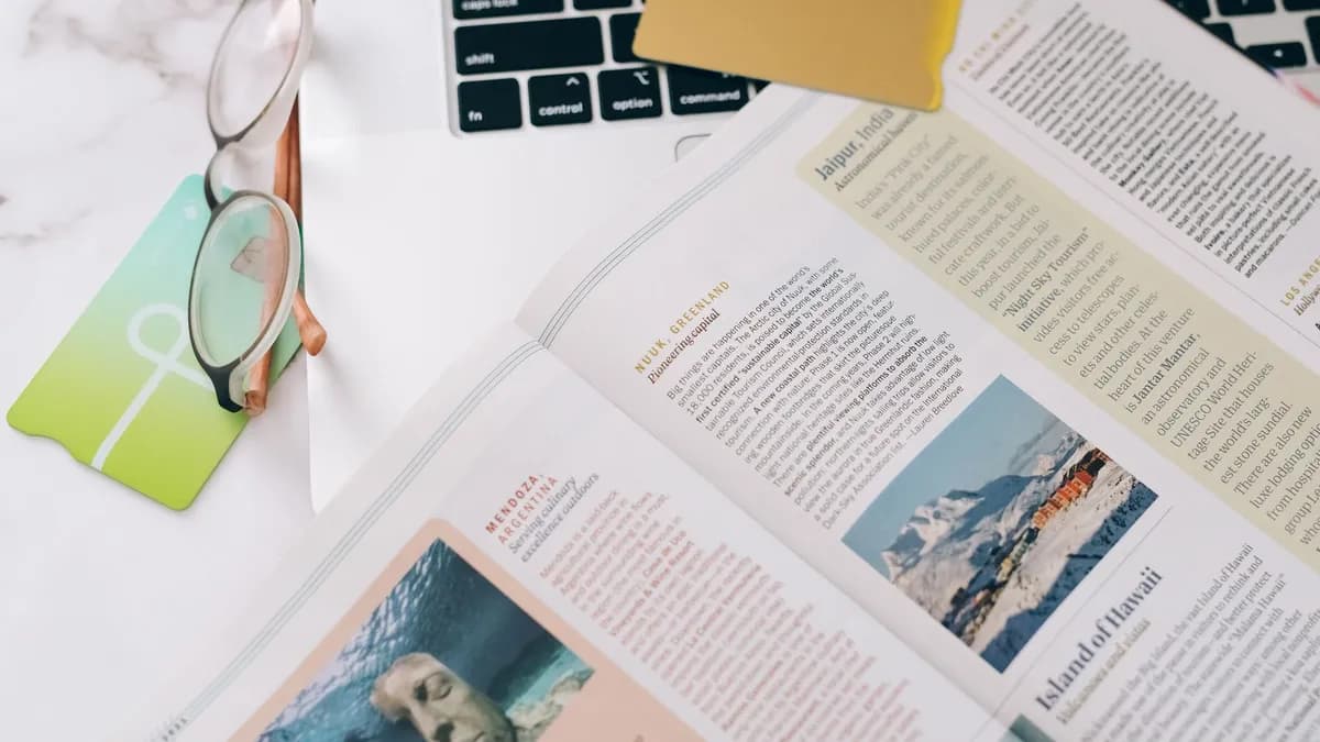 Close-up of a book, glasses, and laptop on a desk, ideal for education or productivity concepts.