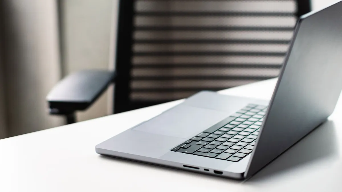 A sleek laptop on a white desk in a modern office setting, ideal for business use.