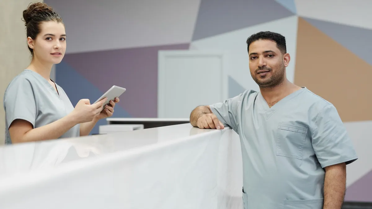 Medical staff members in scrub suits at a modern clinic's reception area.