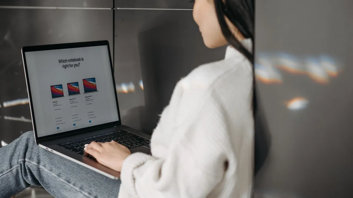 Woman sitting indoors using a laptop. Casual, modern tech vibe.