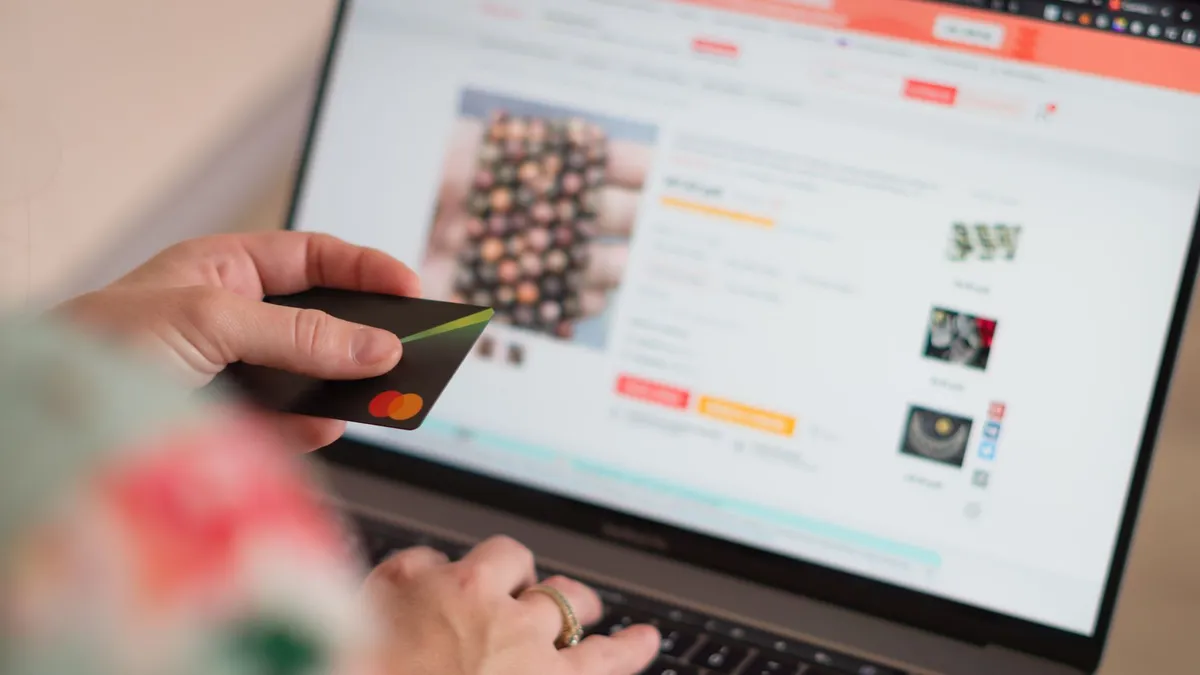 Engaging in online shopping using a credit card with a laptop for convenience and ease.