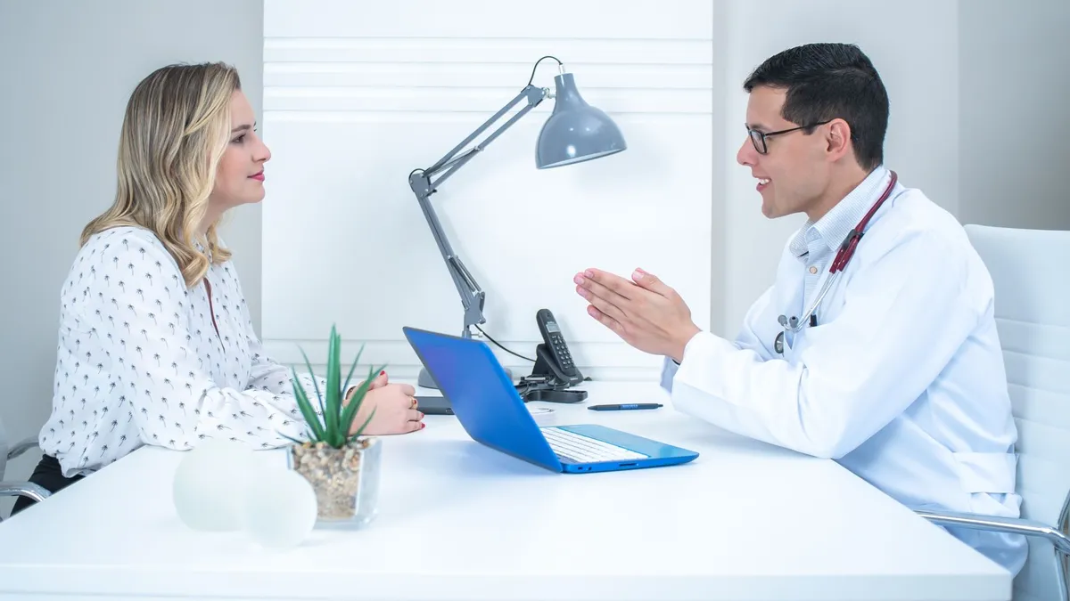 A doctor conducts a patient consultation in a bright, modern medical office.