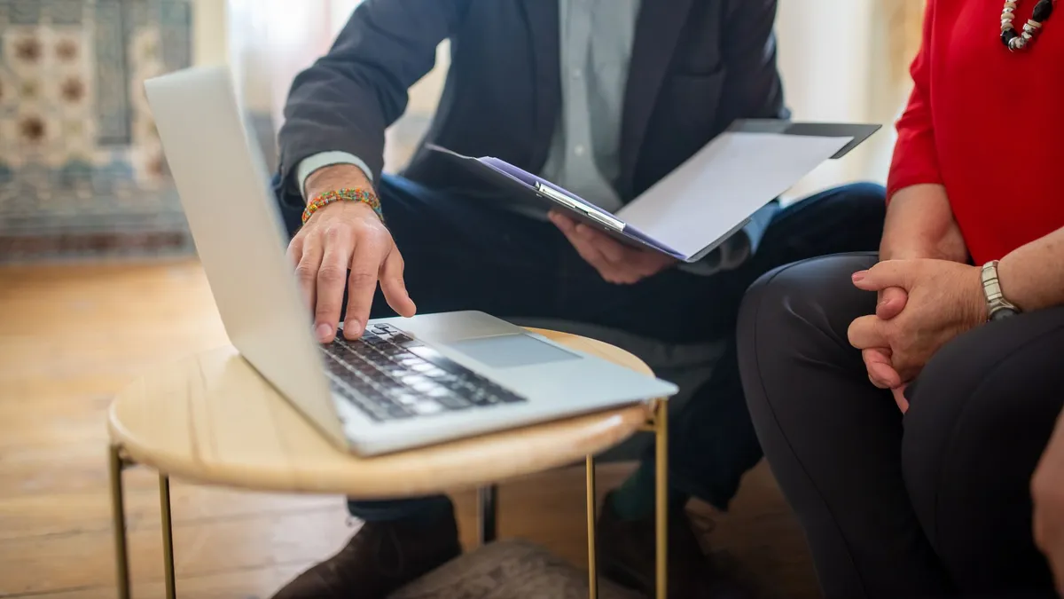 Professional meeting with a laptop and documents in an office setting.