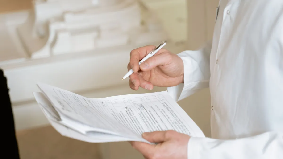 A doctor holds and reviews medical documents, demonstrating careful examination and professionalism.