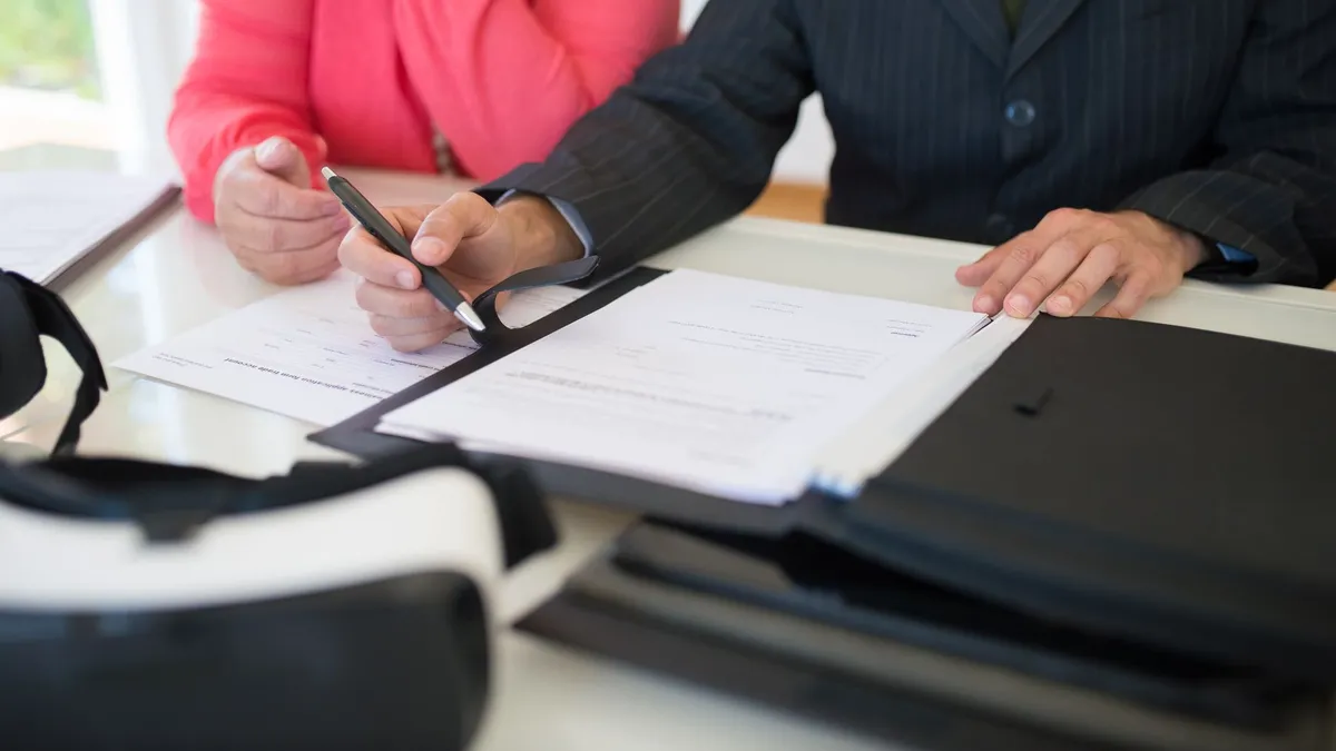 Close-up of professionals signing a business contract indoors, emphasizing agreement and documentation.