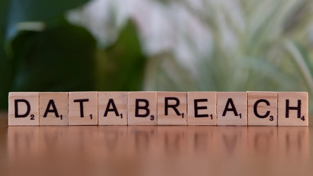 Close-up of Scrabble tiles spelling 'data breach' on a blurred background