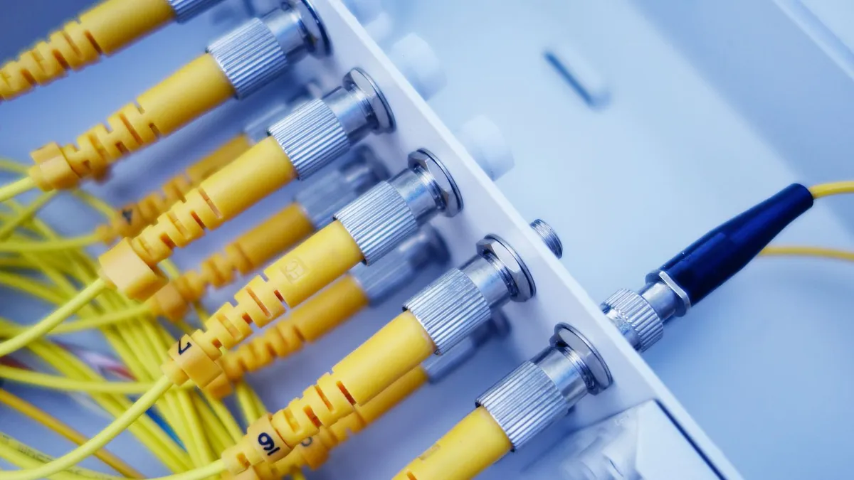 Close-up of yellow fiber optic cables in a network server, showcasing fast data transfer.