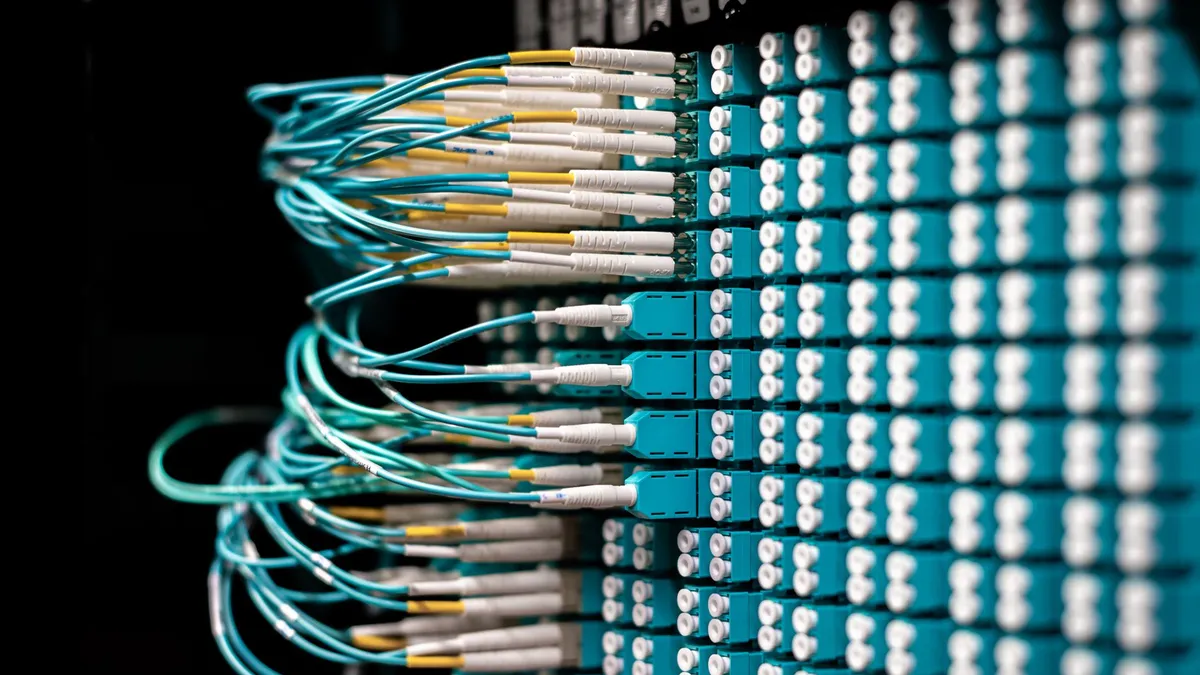 Server with electronic switches and connectors with yellow and green wires plugged in plastic device in operating room on black background