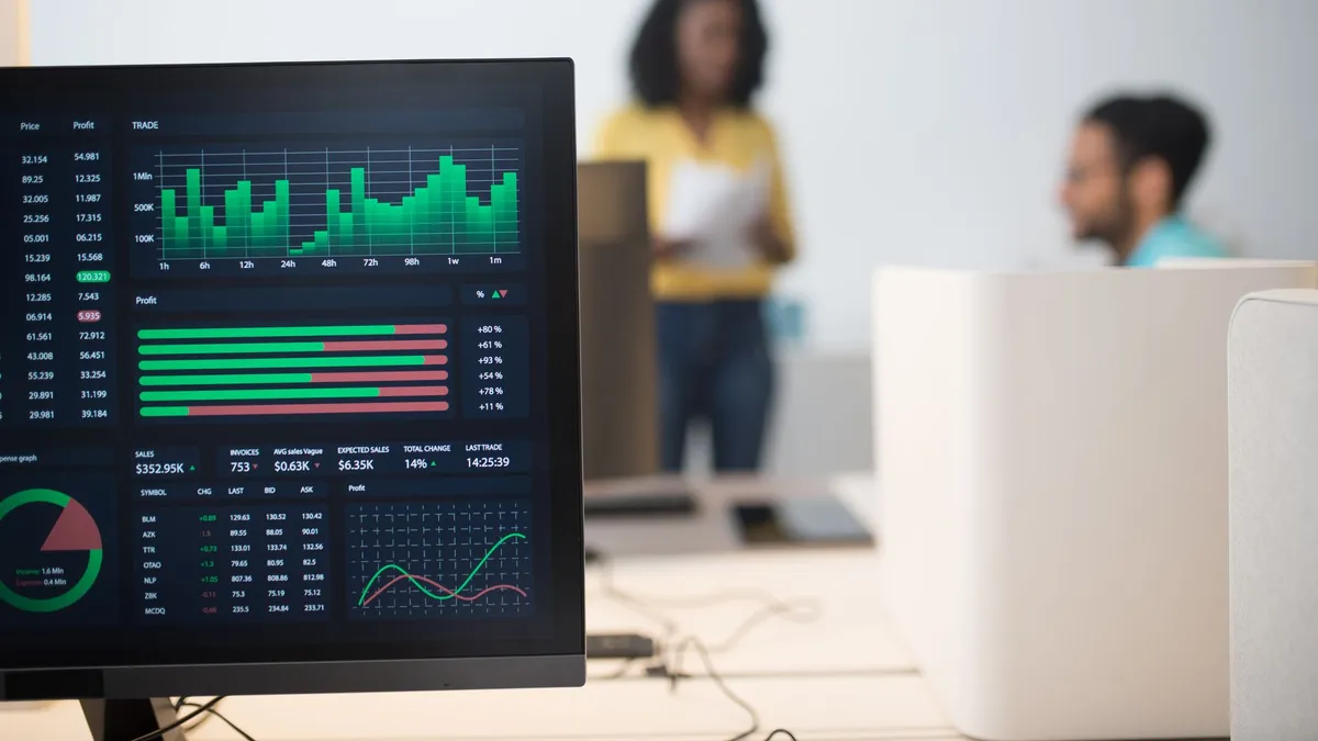 Modern office with financial trading screens and a diverse team discussing strategies.
