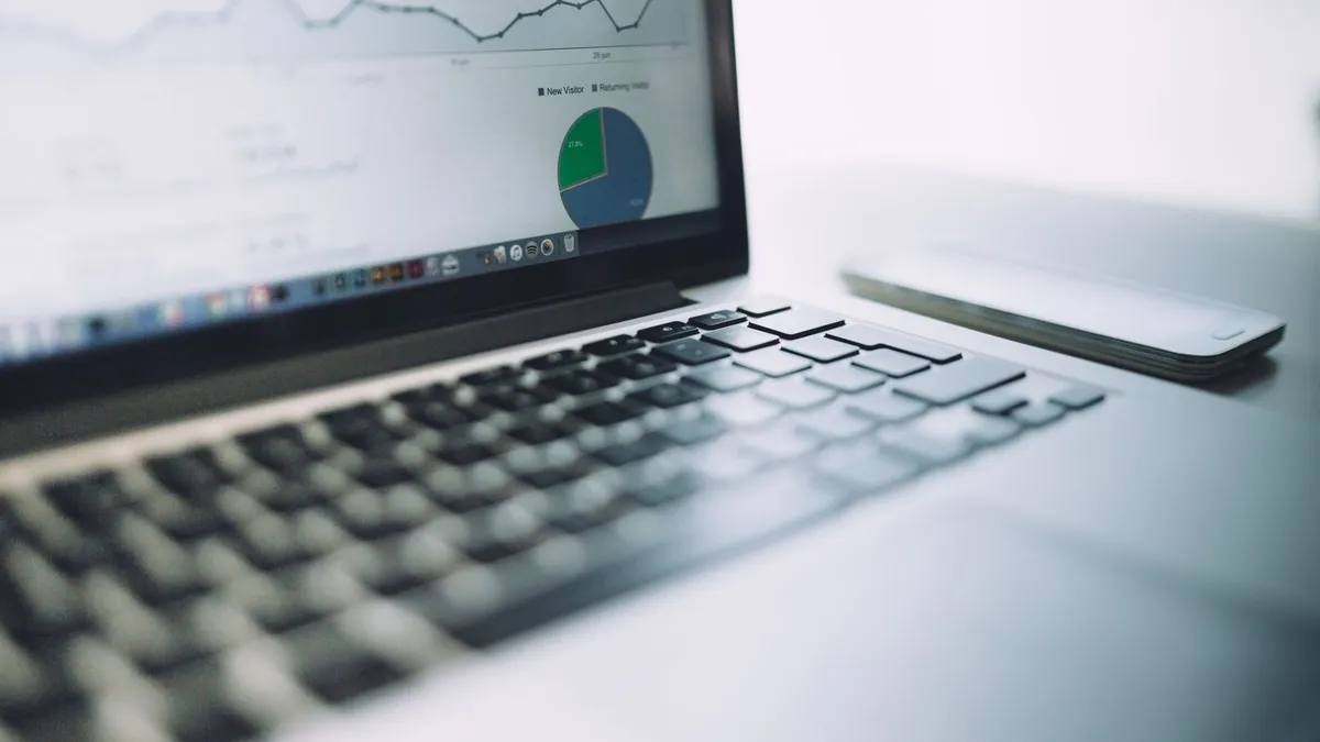 A laptop showing an analytics dashboard with charts and graphs, symbolizing modern data analysis tools.