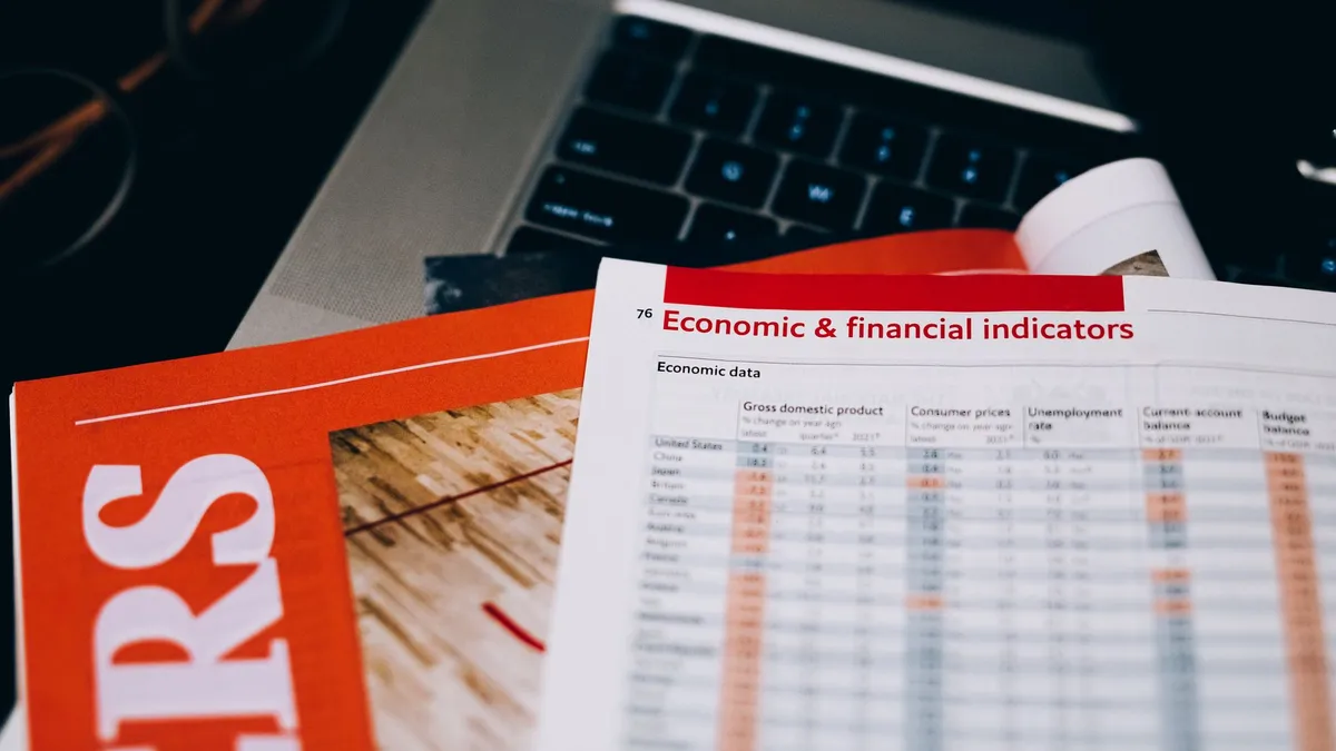 Detailed close-up of economic and financial documents on a laptop keyboard, highlighting data analytics.