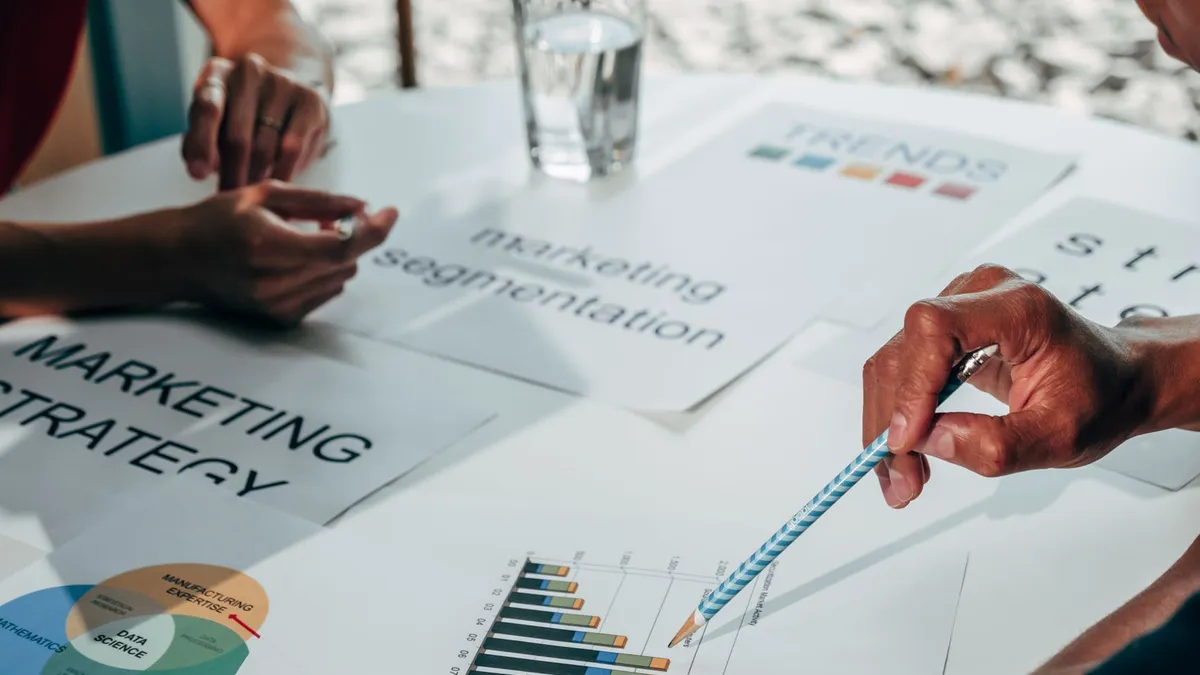 Team working on marketing strategy using data charts and papers in an office meeting.