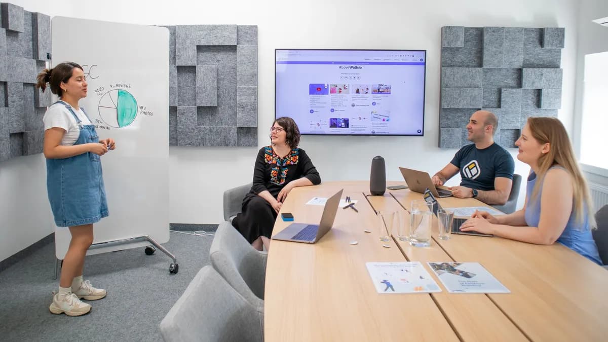 Team collaborating during a meeting with presentation and discussion in a modern office.