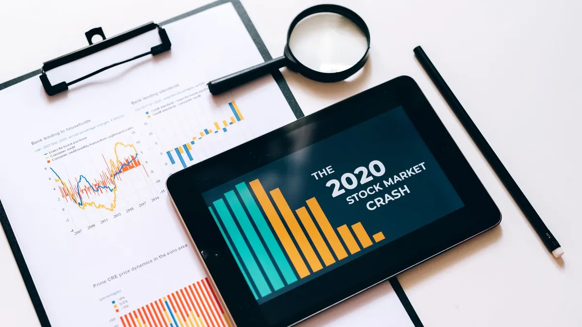 Close-up of financial graphs and digital tablet highlighting 2020 stock market crash.