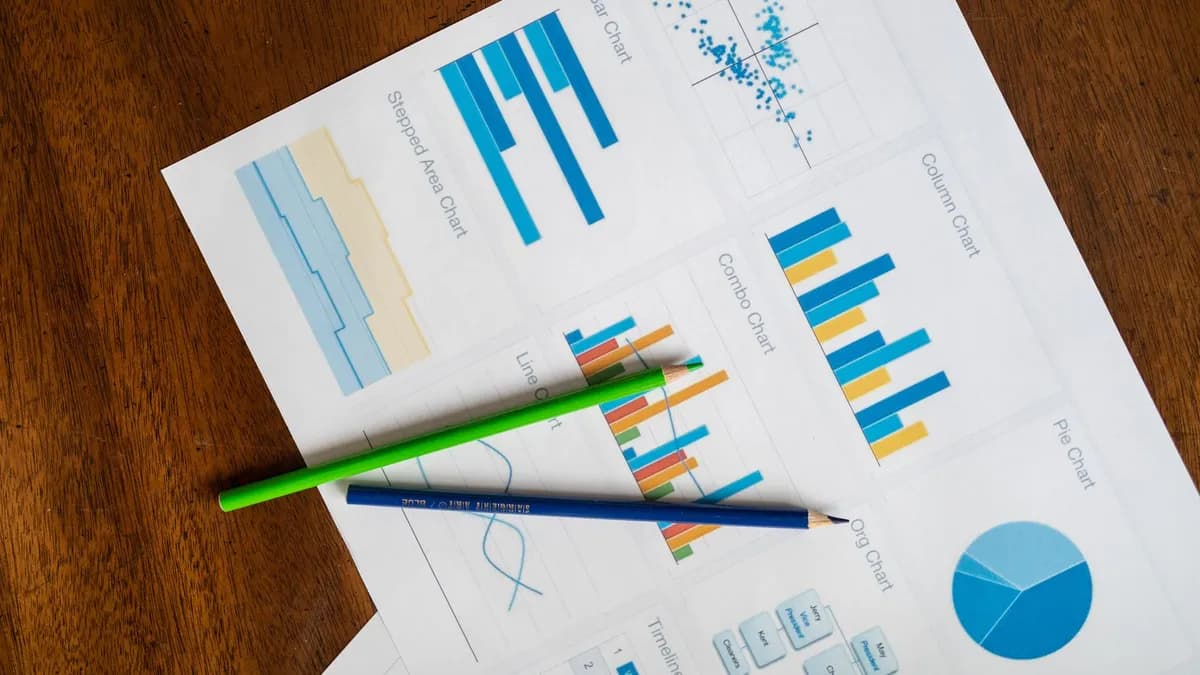 Top view of vibrant charts and colored pencils on wooden surface.