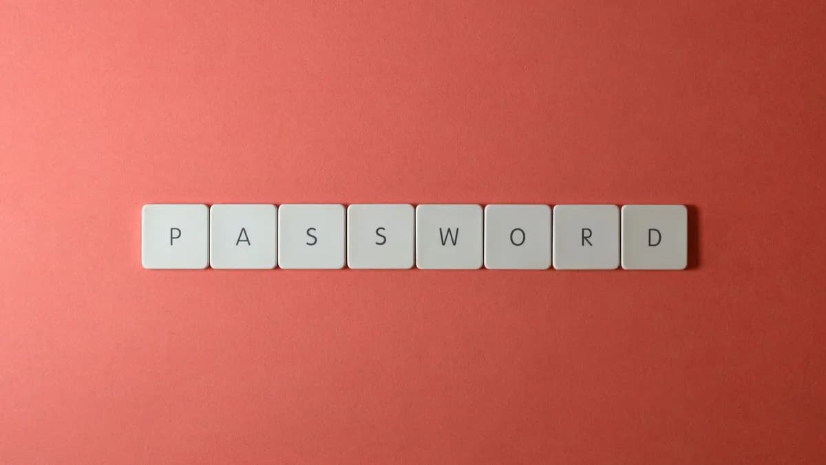 Focus on password security with white keyboard tiles spelling 'PASSWORD' on a coral background.