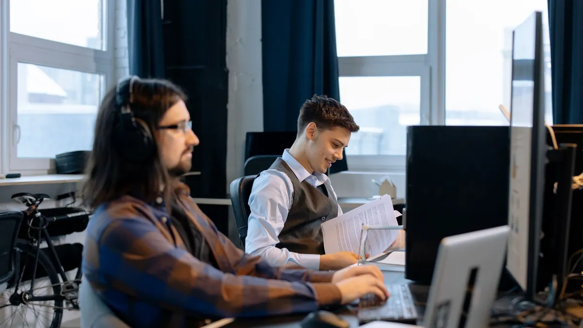 Two men collaborating in a modern office setting, focusing on teamwork and productivity.
