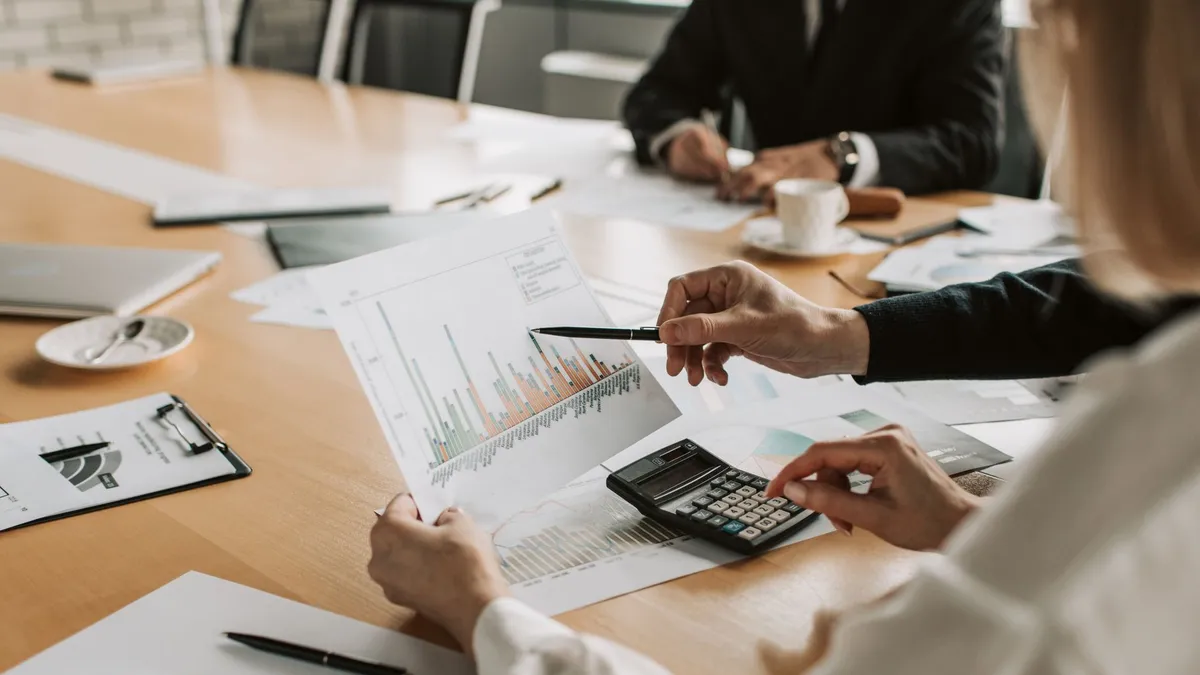 Professionals reviewing financial graphs and charts during a meeting.