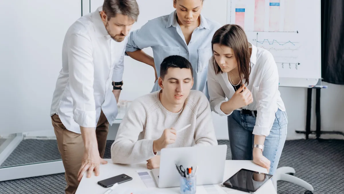 Group of professionals collaborating on a project with graphs in an office setting.