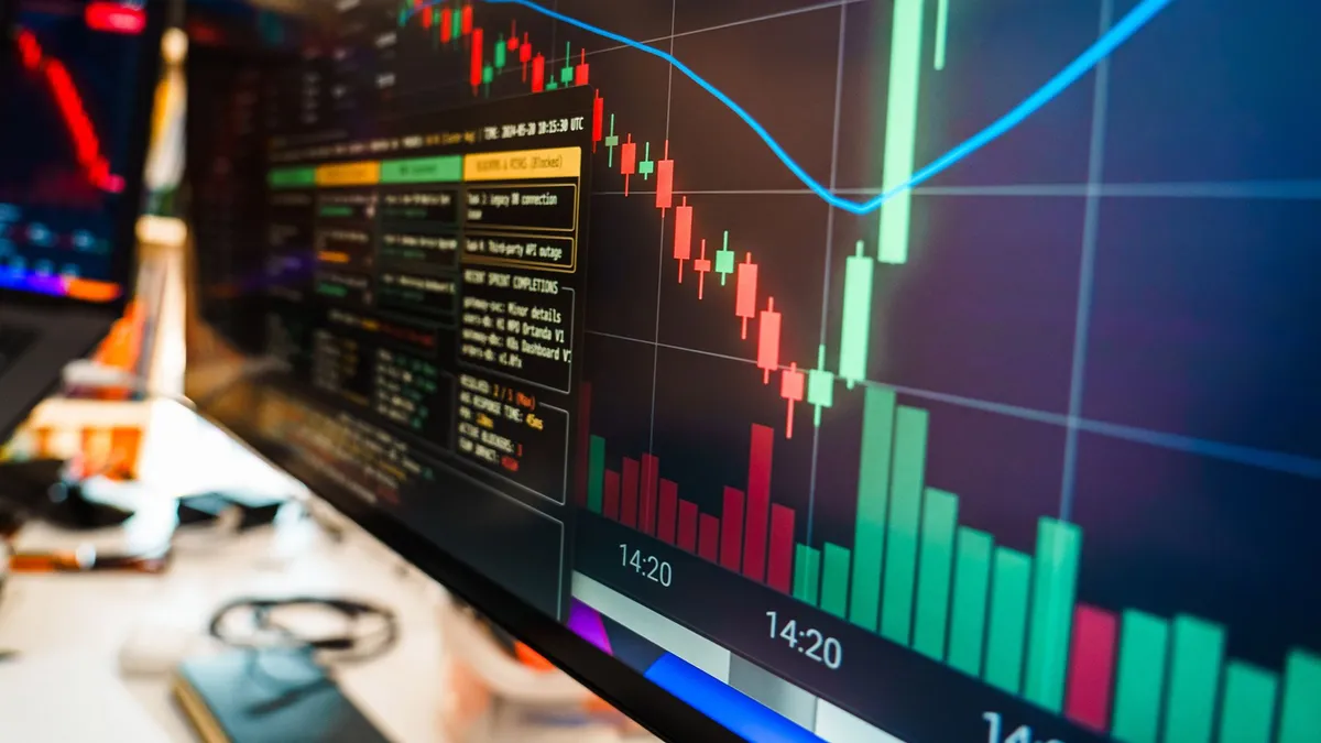 Close-up of a financial monitor displaying real-time cryptocurrency data and charts in a modern office.