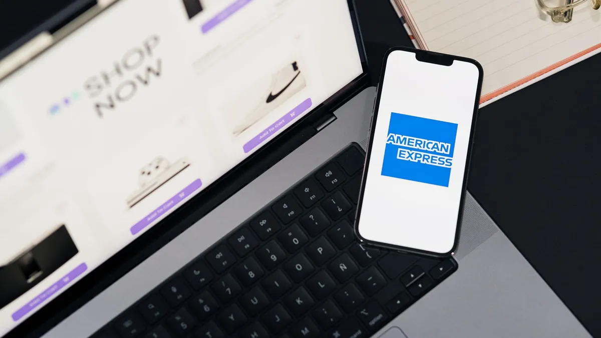 Smartphone displaying American Express logo on a laptop for online shopping convenience.