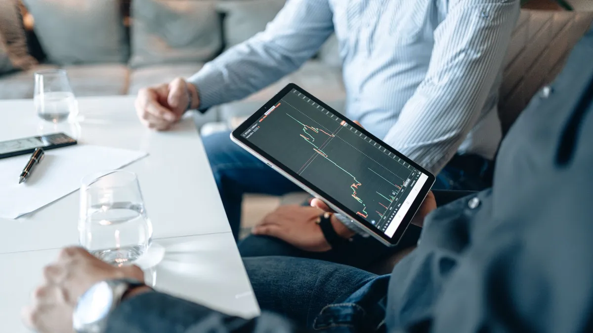 Professionals analyzing business data on a digital tablet during a meeting.