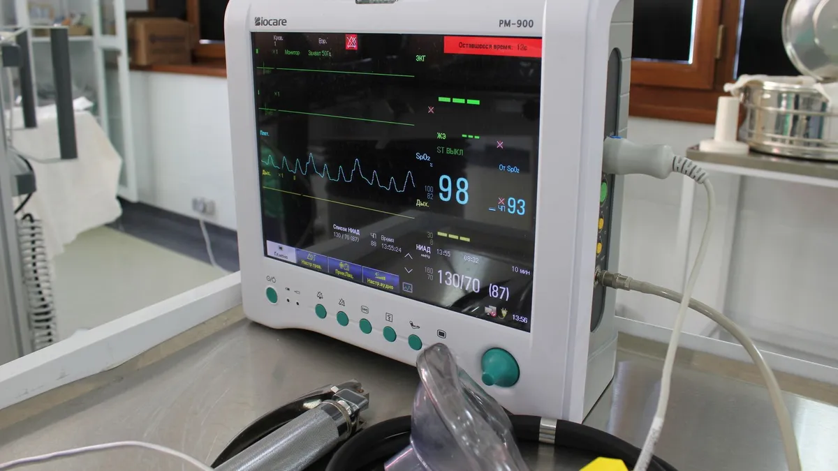 Close-up of an advanced medical monitor displaying ECG data in a clinic.