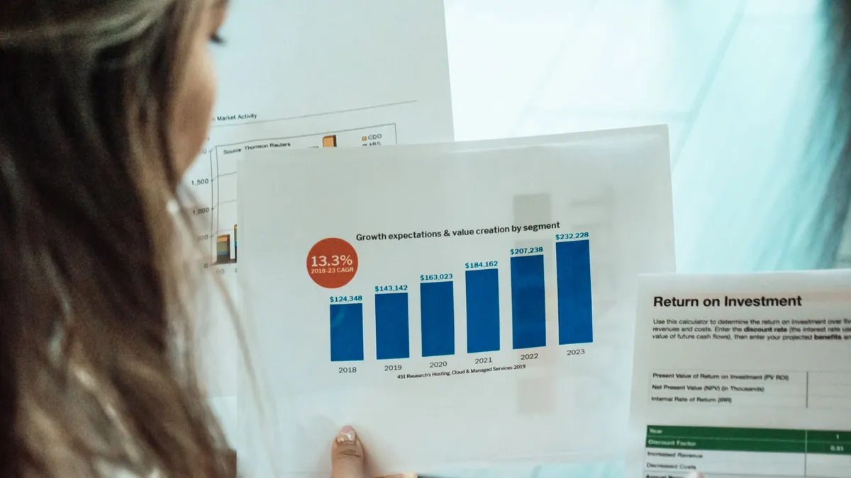 Person analyzing financial graphs and ROI reports, focusing on investment growth.