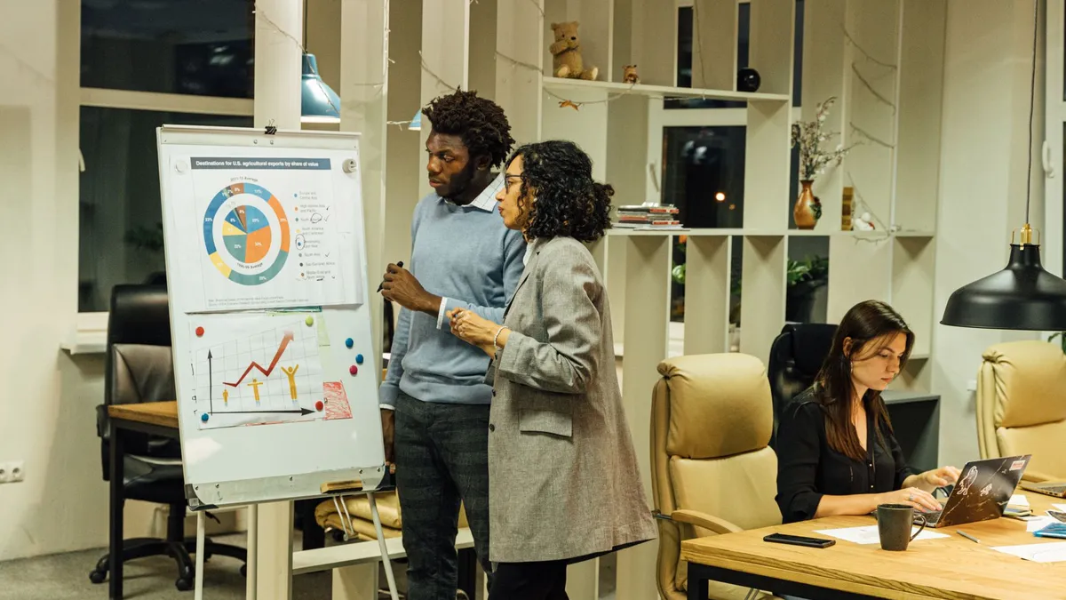 Colleagues working on a business report using charts in a modern office setting.