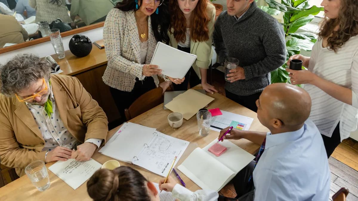 A diverse team discusses documents around a table in a modern office setting, promoting teamwork and collaboration.