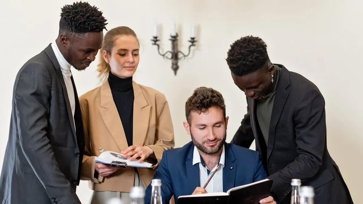 A group of professionals engaged in a collaborative business meeting in an office setting.