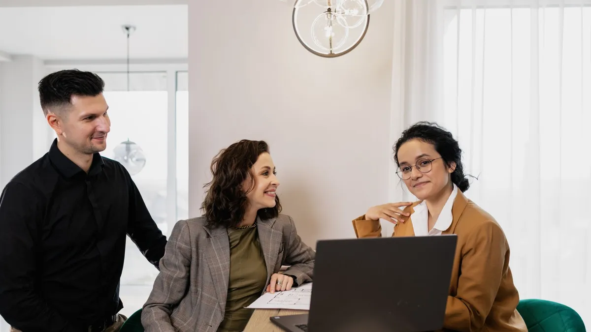 Professional business meeting with real estate consultant and couple in an office setting.