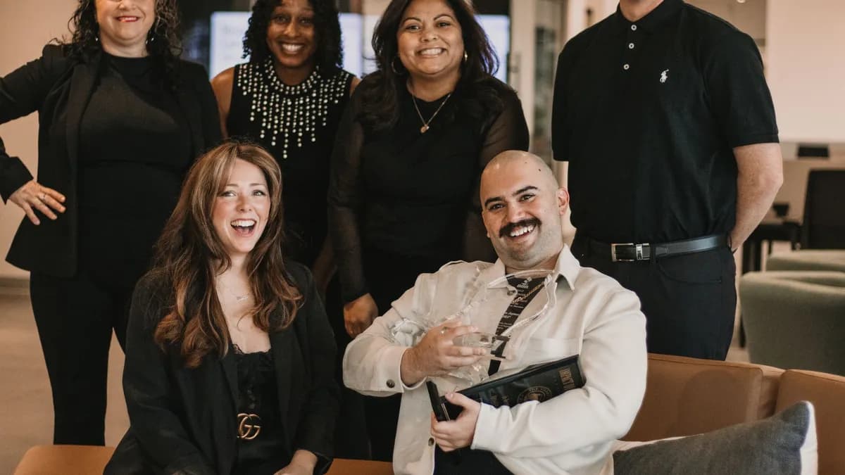 Diverse group of real estate professionals posing confidently in office environment.