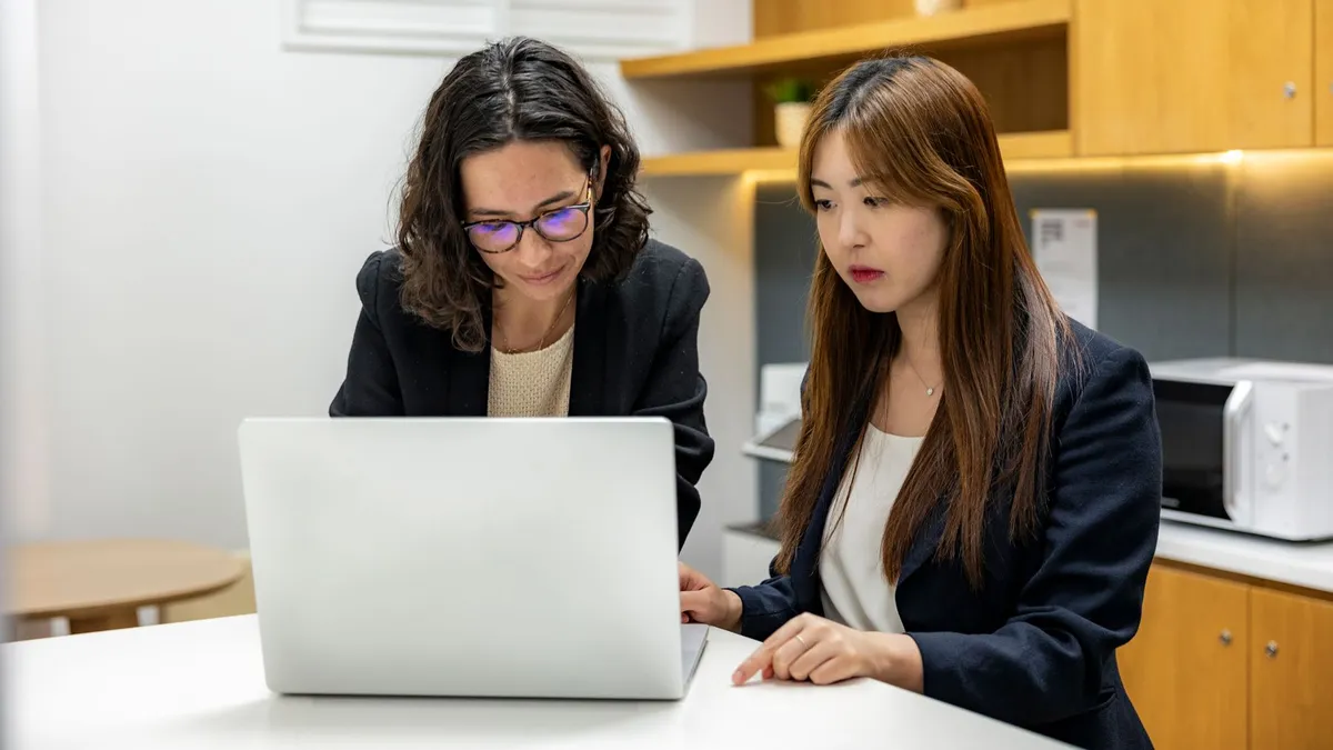 Two professionals working together in a contemporary office environment with technology.