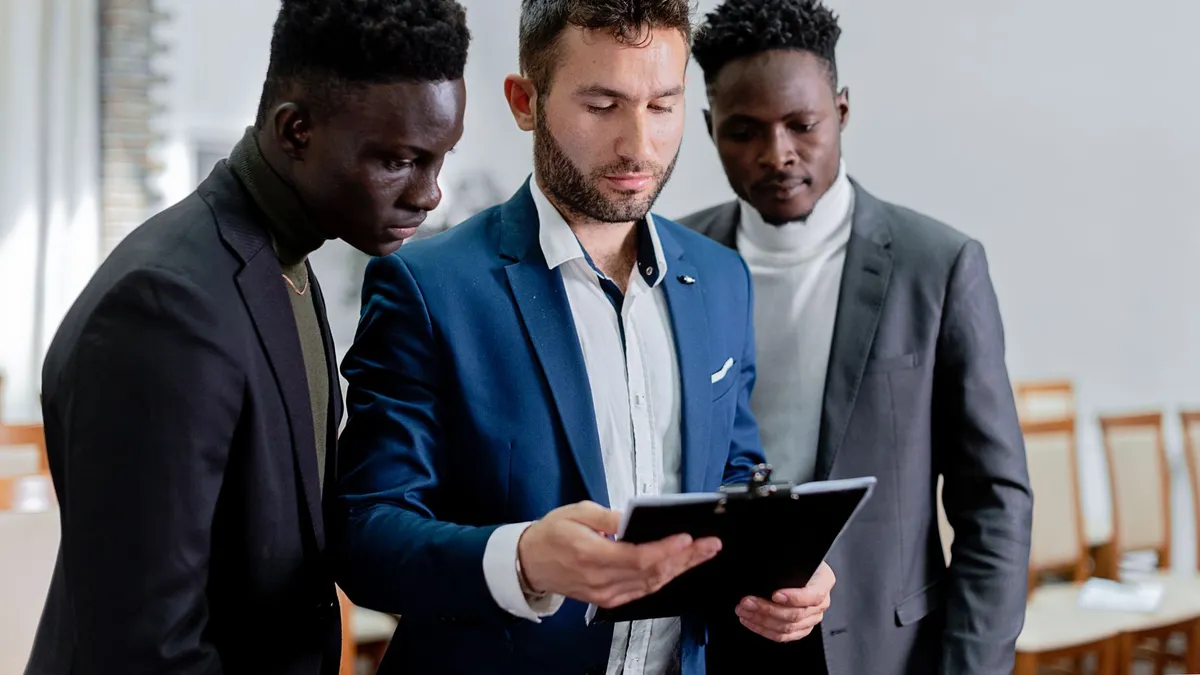 Three diverse business professionals collaborating indoors, focusing on teamwork.