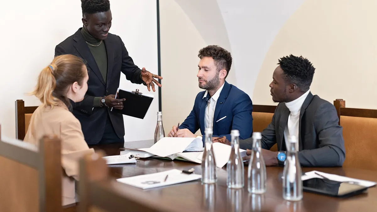 Multicultural team having a discussion in a modern conference room setting.