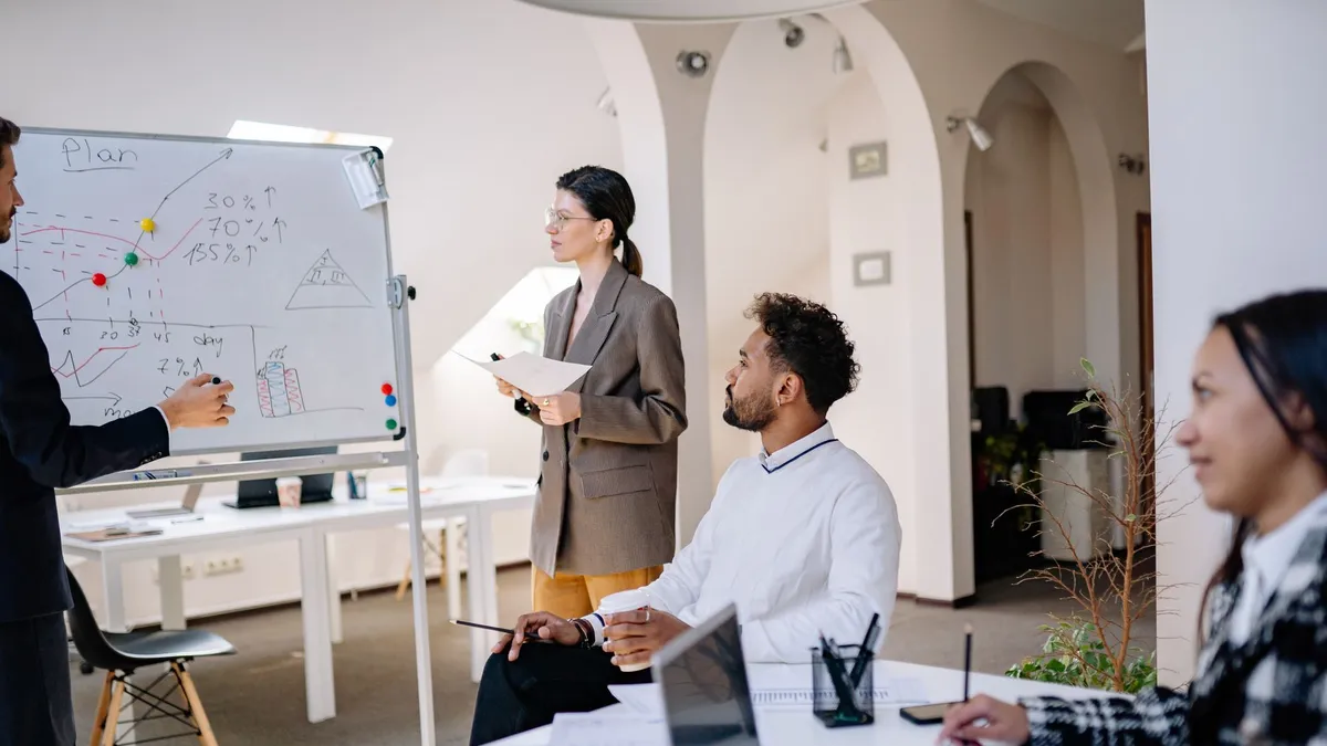 A diverse group of colleagues discussing ideas during a team meeting in a modern office setting.