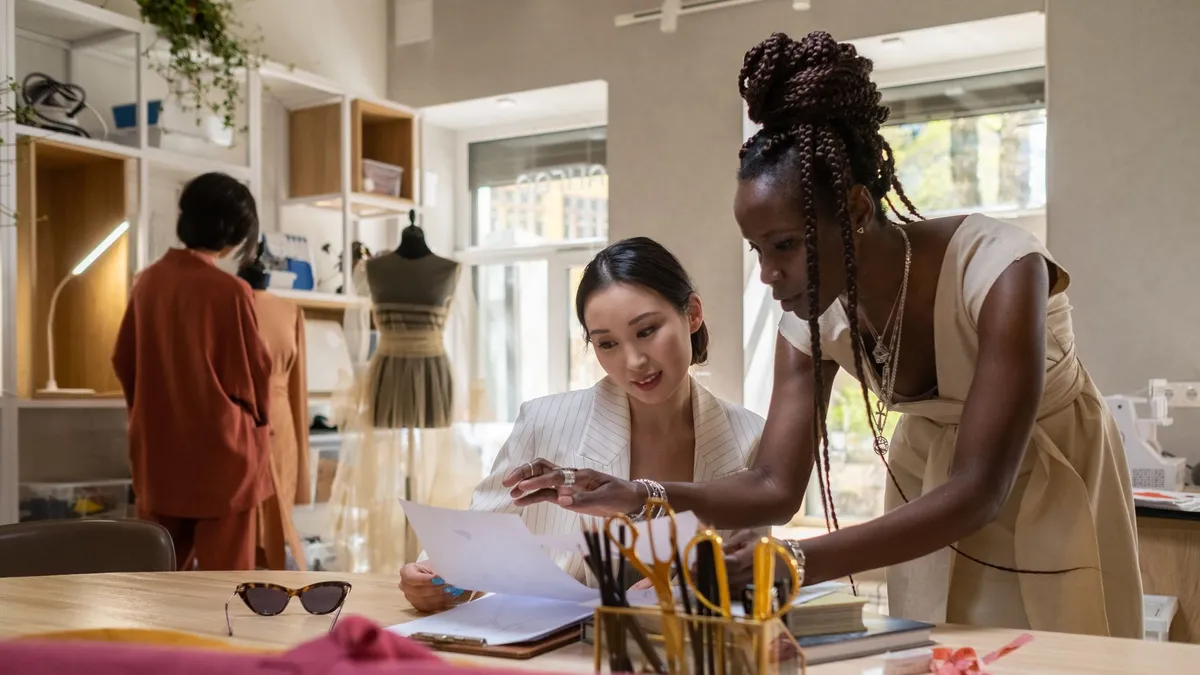 Fashion professionals collaborating in a modern design studio, reviewing creative designs.