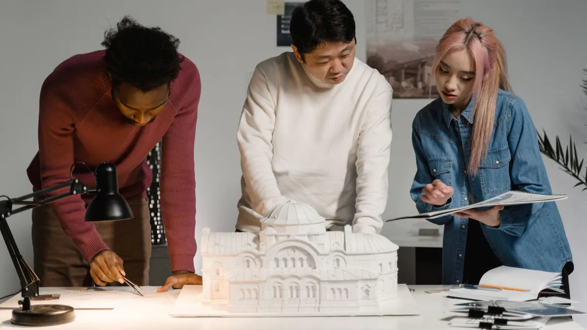 Architects discussing and planning a scale model in a modern office setting.