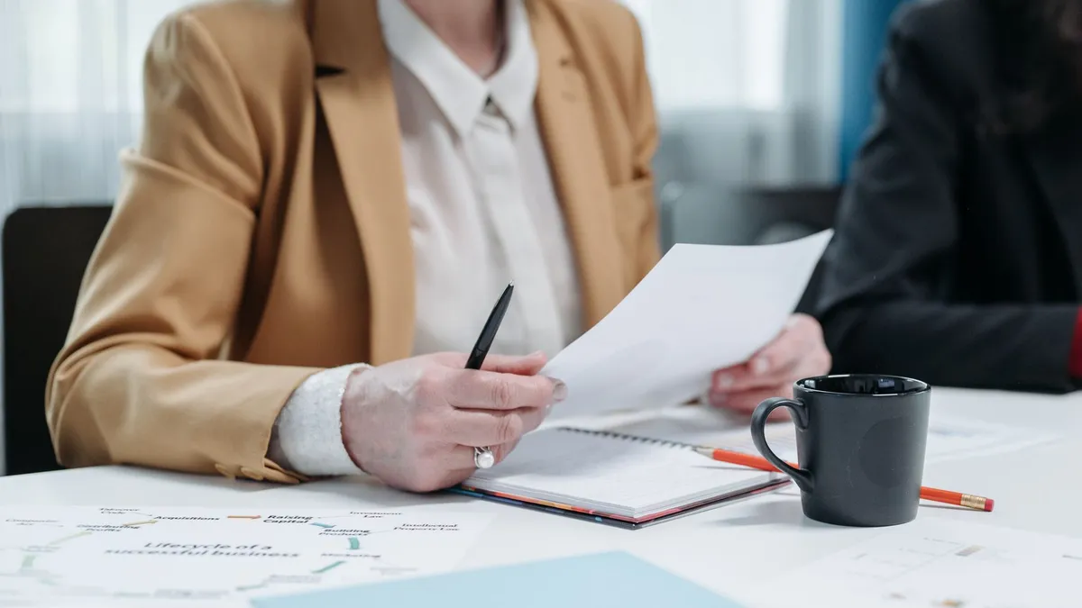 A senior woman reviews documents at a business meeting, highlighting professionalism.