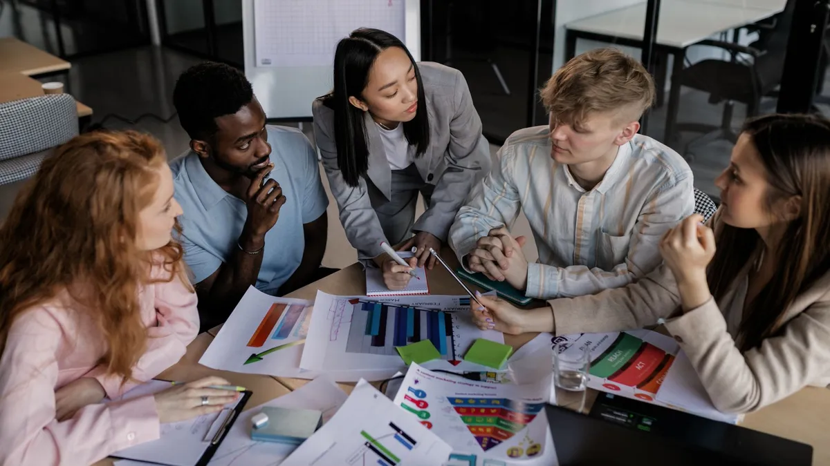 Diverse group of colleagues brainstorming and discussing strategy in a modern office setting.